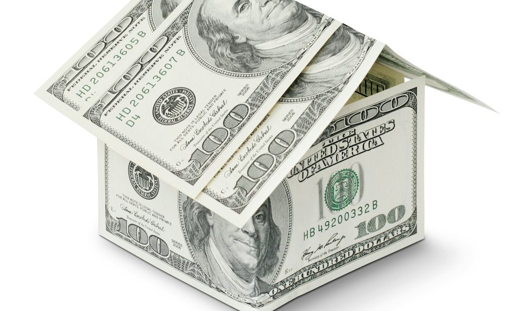 A house made of folded hundred dollar bills representing finance and investment concepts